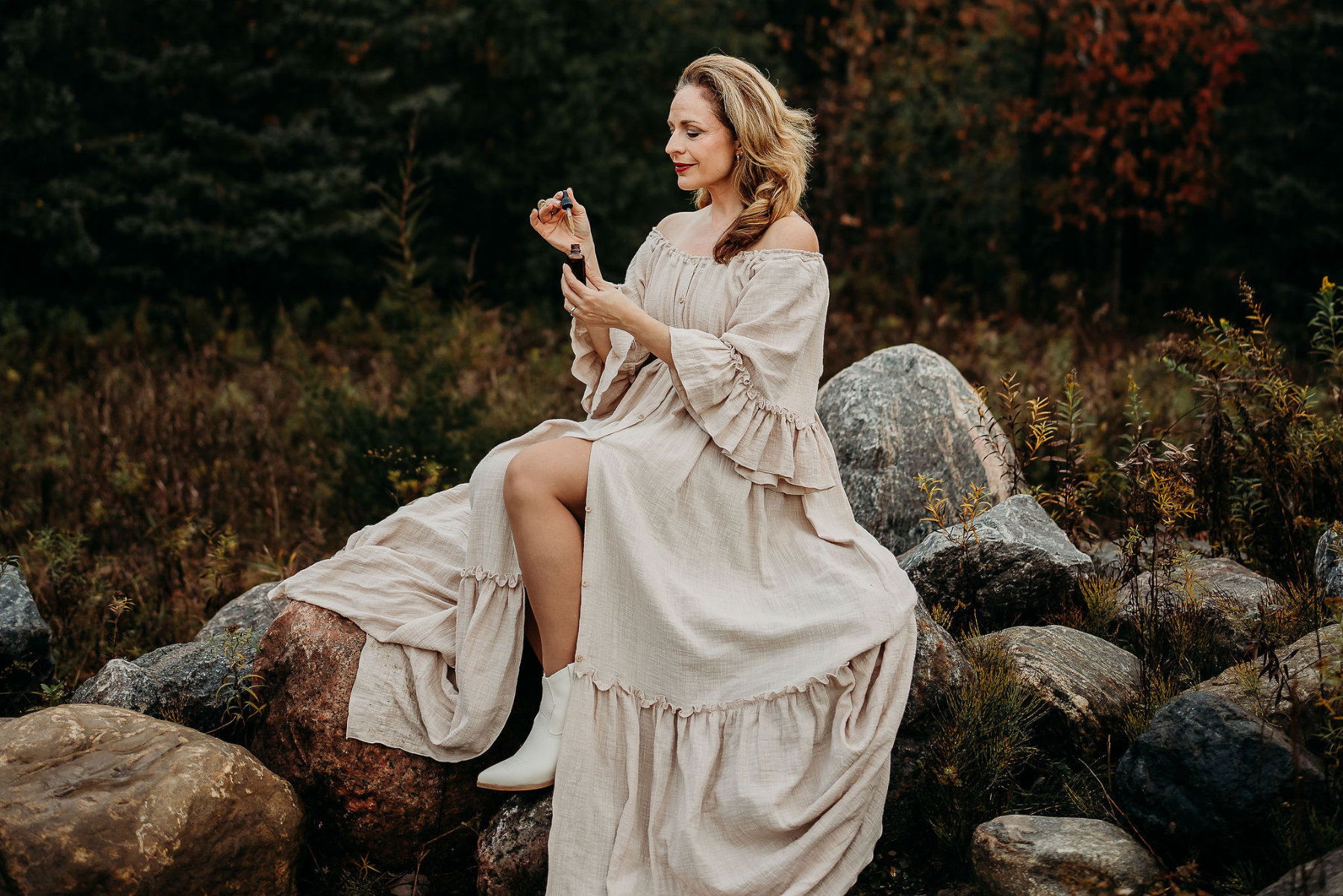 Maria Velve sitting on rock holding a serum